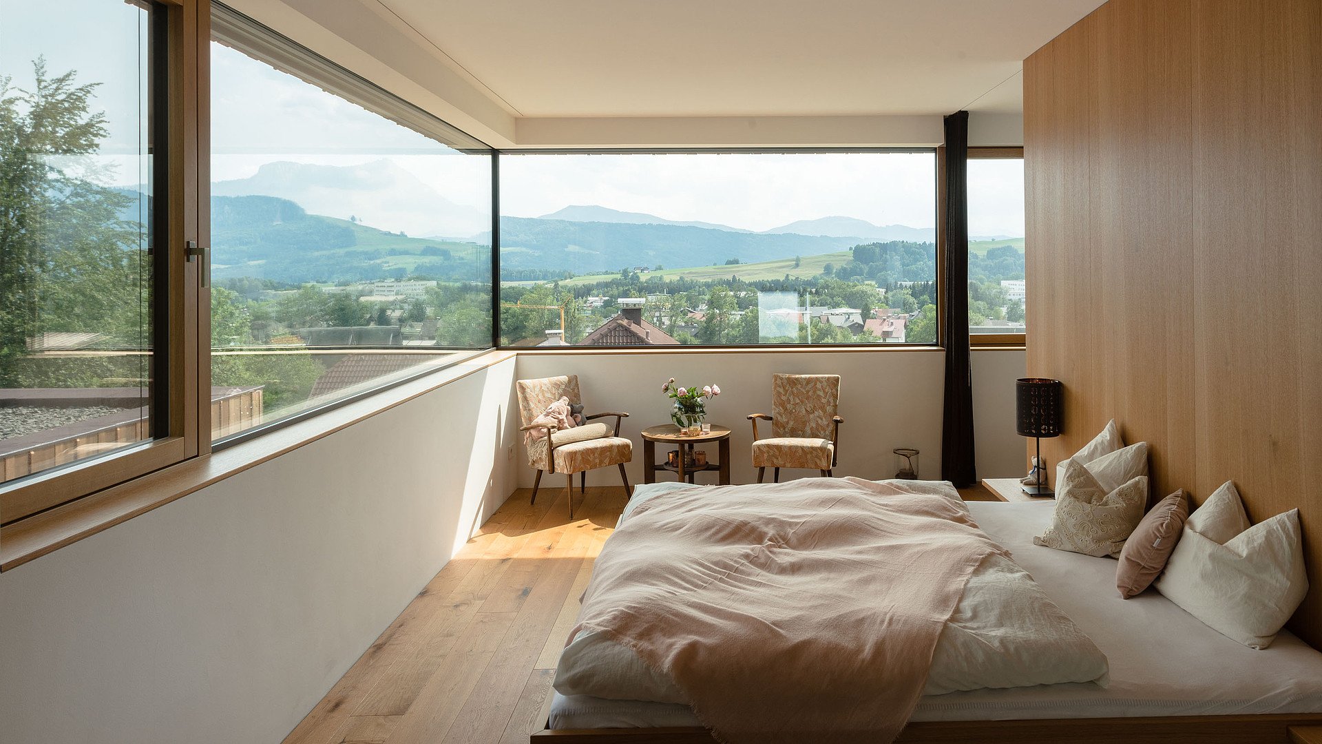 Modernes Schlafzimmer mit großzügigen Panorama-Fenstern und weitem Ausblick – hochwertige Fensterlösungen in Esslingen für lichtdurchflutetes Wohnen und stilvollen Sonnenschutz.