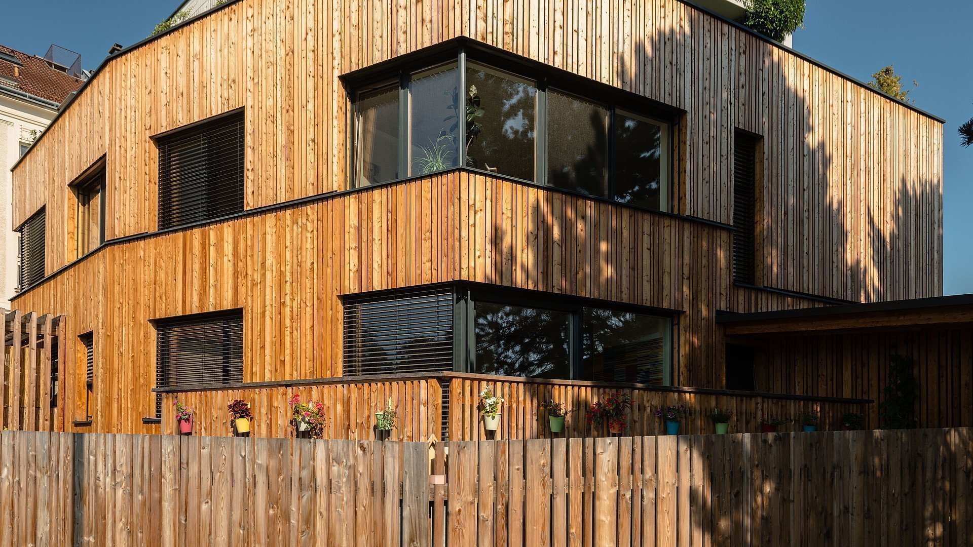 Modernes Holzhaus mit großen Aluminium-Fenstern und integriertem Sonnenschutz – hochwertige Fensterlösungen und moderne Architektur in Esslingen für energieeffizientes Wohnen.